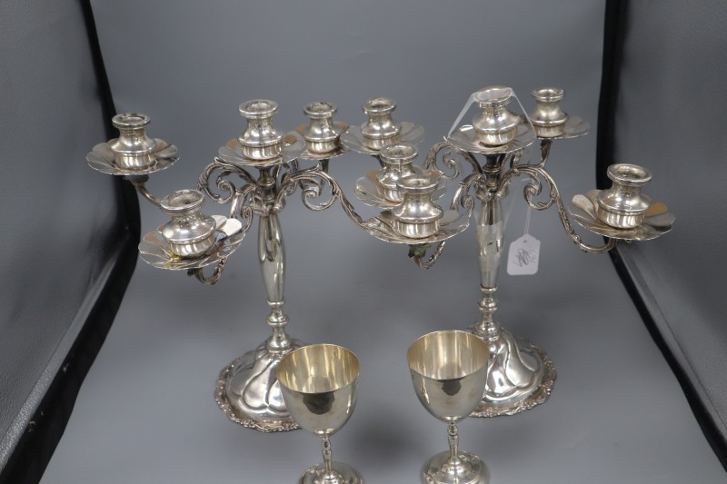 A pair of continental 900 standard white metal candelabra(a.f.) height 34cm and a pair of sterling goblets, gross weight 146.5oz.